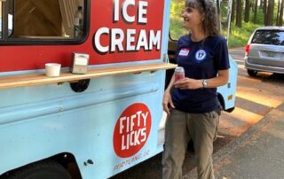 Image of a Portland member in their PROTEC17 shirt ordering something from the Fifty Licks Ice Cream Truck at the Portland social.